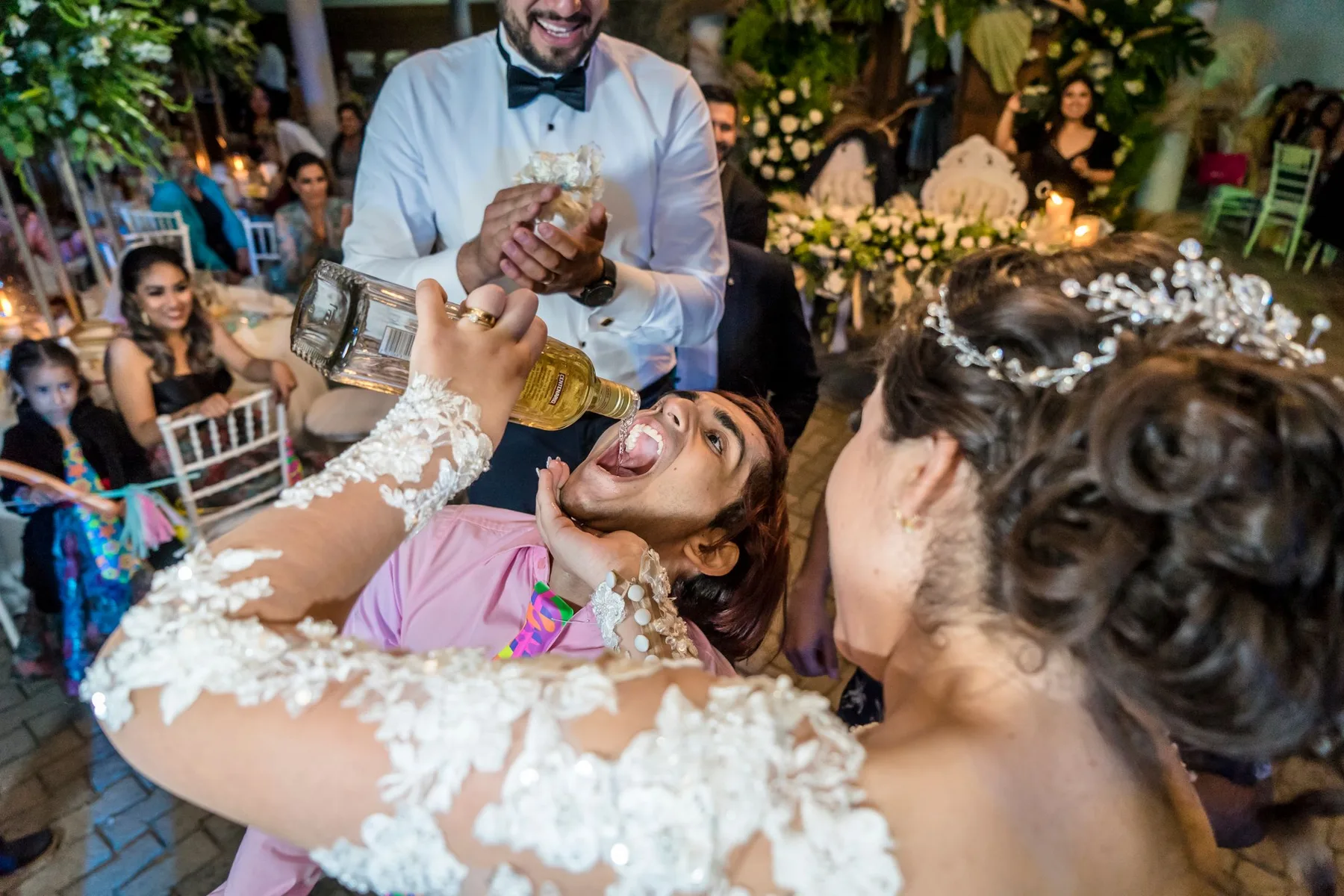 Guests laughing as the couple feed each other cake