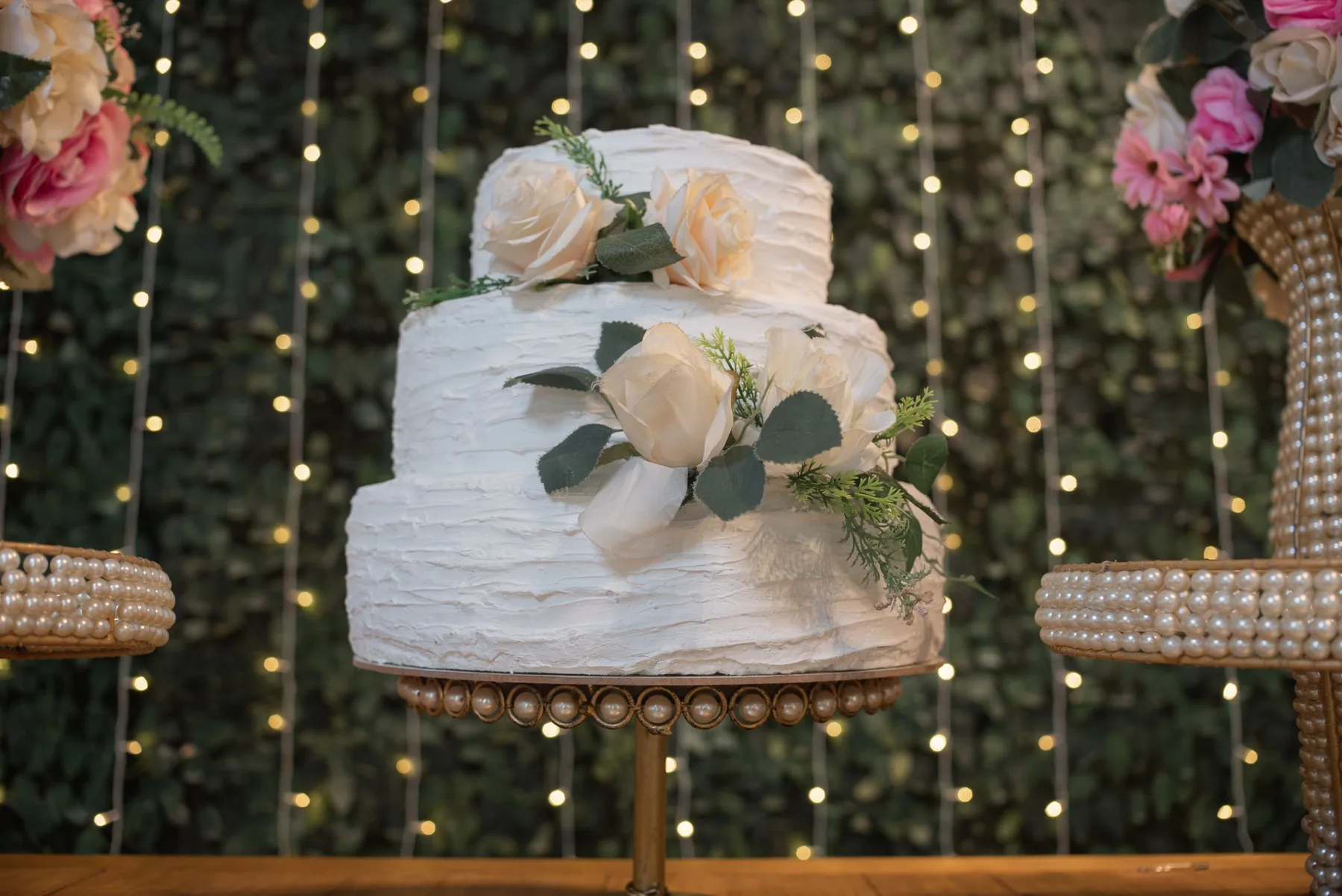 The couple cutting a cake while guests lean in to watch